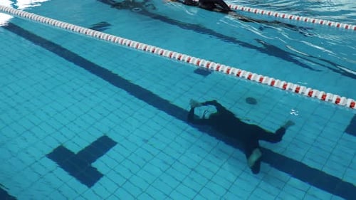 Competidor de apnea en piscina cubierta sin aleta