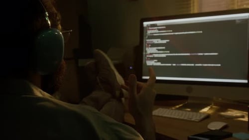 Male Programmer Rocking in Chair with Feet Up on Desk, Spinning Pencil in Hand