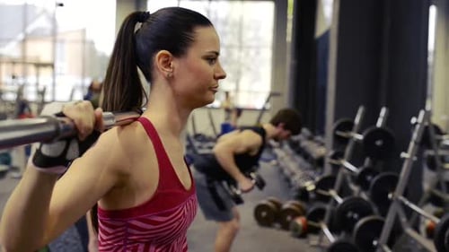 Young People in Gym Working Out with Various Barbells Active