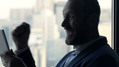 Successful Businessman with Tablet Computer Standing by Window in Office Achievement