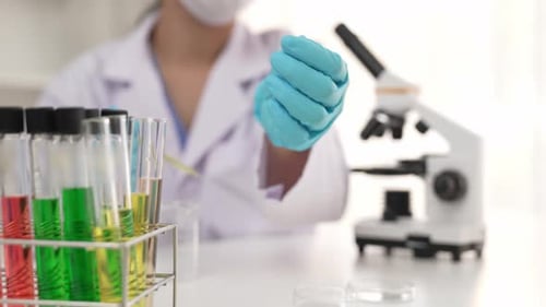 Scientist Analyzing Liquid Sample with a Microscope