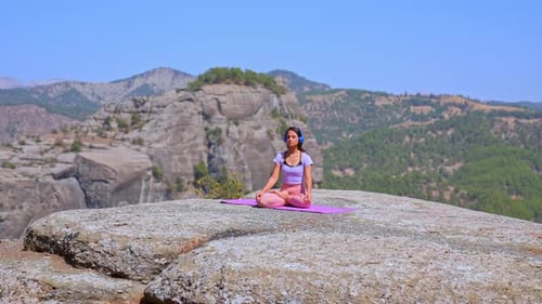 Woman Practicing Yoga Balance Pose on Cliff with Mountain View