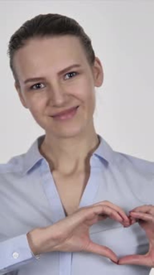 Smiling Woman Makes Heart Shape With Hands