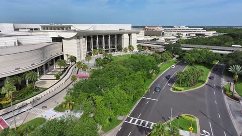 Modern Orange County Convention Center in Orlando with tropical neat garden park. Bridge and cars in