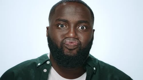 Portrait Positive African American Man Making Funny Faces in Grey Background. Closeup