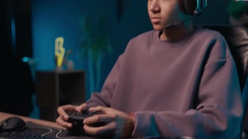 Kid in Headset Using Joystick Playing Computer Games at Night