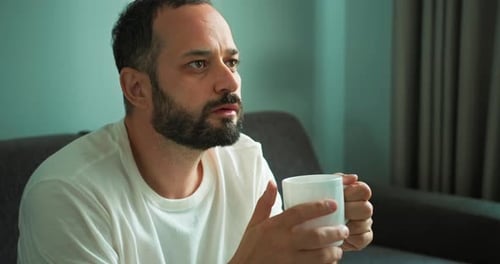 Man Drinking Beverage from Mug Inside Home