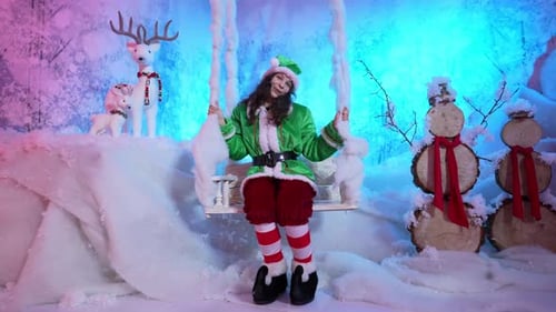 Woman Dressed as Elf on Swing in Winter Scene