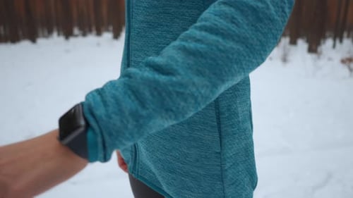 Person Using Activity Tracker in Snowy Woods