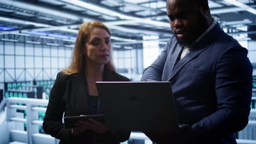 Coworkers in Server Room Optimizing Data Center Hardware Equipment