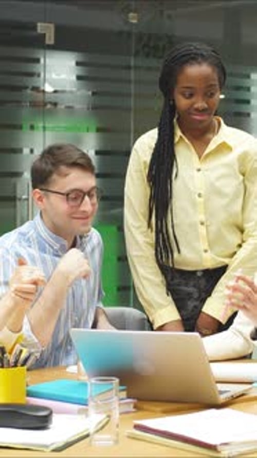 He Creative Team Brainstorms and Discusses Innovative Ideas on a Laptop in a Modern Office