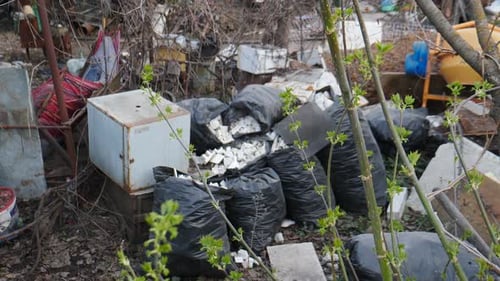Dump Site with Black Garbage Bags and Debris