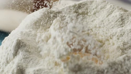 Egg Yolk Falling Into Flour Volcano for Baking