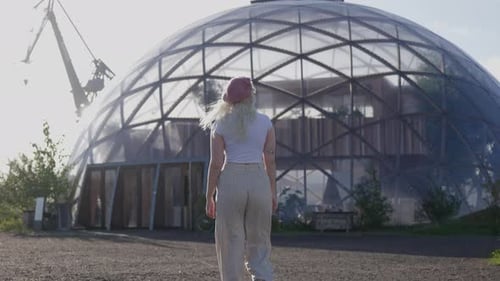 Woman Walks Towards Glass Geodesic Dome Building