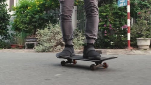 Man in Grey Jeans and Sneakers Riding on Skateboard
