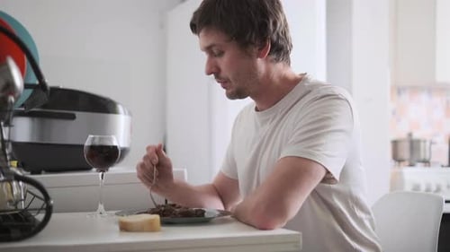 Man Eating Meal Alone at Kitchen Table