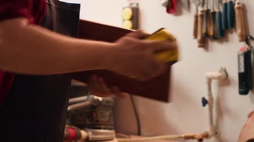 Person Sanding Wood in a Workshop