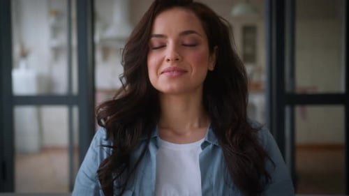 Serene Woman Meditating Calmly at Home on Sofa