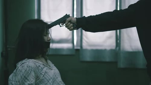 Criminal with gun and woman hostage with hands and feet tied to a chair, Hostage of terrorist man