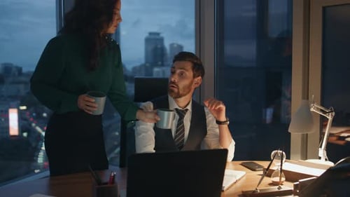 Woman Bringing Coffee Colleague Working Together in Office Late Evening