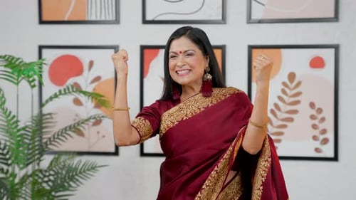 Excited Woman Celebrates with Arms Raised Indoors