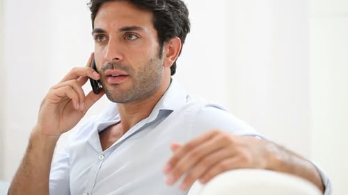 Portrait of Worried Young Man on the Phone. Business Man Sitting On