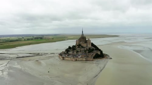 The mont saint Michel drone camera is heading towards the site and there are many tourists