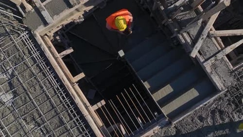 Vidéo aérienne : des grues fonctionnent pour couler du béton aux étages supérieurs d'un immeuble de grande hauteur situé sous