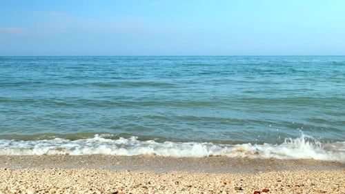 waves of the turquoise water crash on an italian beach of the adriatic sea in a sunny summer day, st