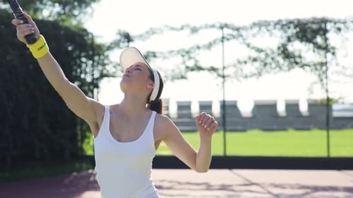 Woman playing tennis on outdoor court in daytime
