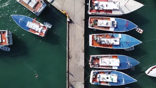 Píer aéreo com barcos de pesca atracados durante o dia ensolarado no porto. Venezuela, América do Sul.