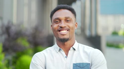 close up portrait happy African American man looking at camera outside. Face of smile young adult