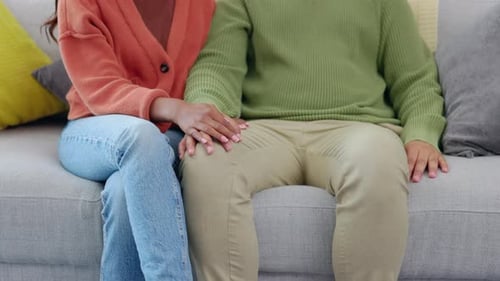 Man and Woman Holding Hands on Sofa