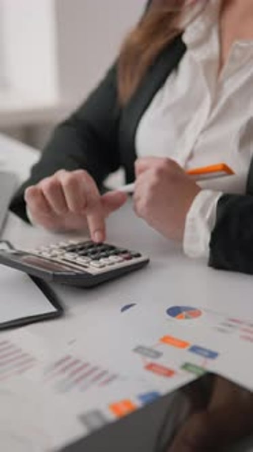 The Professional Businesswoman Meticulously Analyzes Financial Data Using a Calculator and Pen at