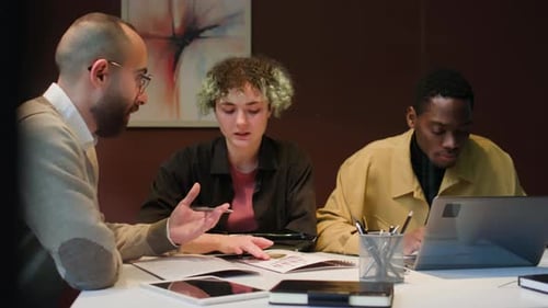 Executive Manager Discussing Graphs with Two Multi-ethnic Coworkers