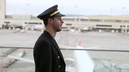 Confident Pilot Standing near an Airplane at Airport