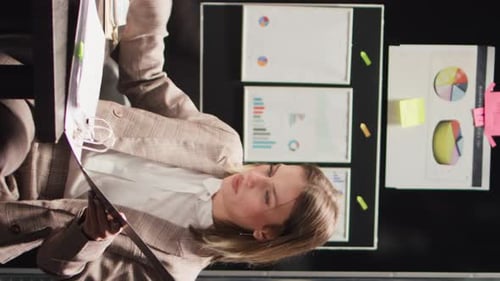 Woman Reviews Data at Workplace Office Desk