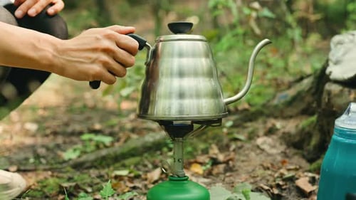 Woman Prepares Hot Drink on Camp Stove in Nature