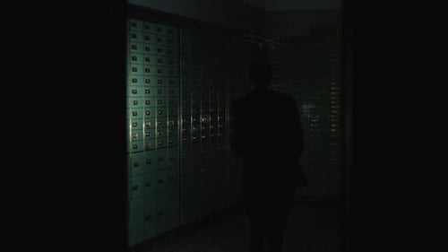 Man Unlocks Safe Deposit Box in Bank Vault at Night