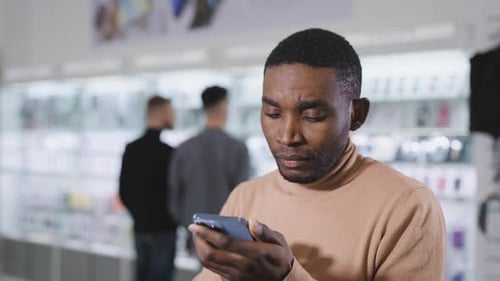 African Man in Electronics and Gadgets Department