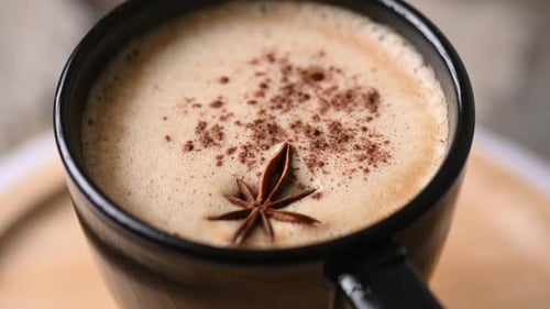 Chai Latte en taza negra con especias (anís estrellado y canela)