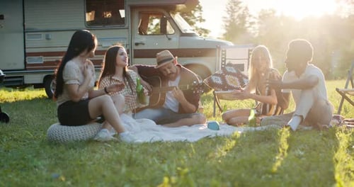 A Crew of Friends is Spending Time Together at the Lake in the Open Air Next to the Camper They Came