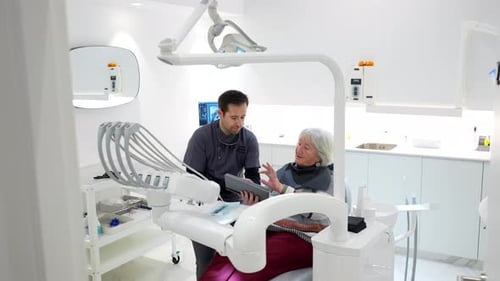 Dentist Showing Tablet to a Senior Patient
