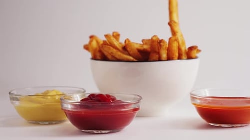 Close Up of Ketchup Sauce Dunking French Fries in Sweet and Sour Sauce Close Up Fast and Junk Food