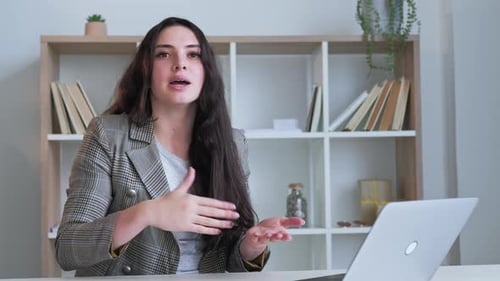 Young Woman Gesturing Explaining From Desk