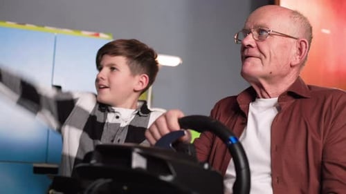Child and Senior Enjoy Racing Game Together