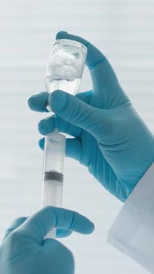 Medical Professional Extracting Liquid with Syringe