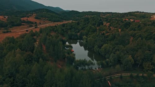 A Stunning Aerial View Showcasing the Serene Forest and Beautiful Waterbody Landscape Nearby