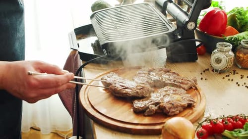 Young Chef Preparing Grilled Meat Steak in a Modern Kitchen The Man Prepares Food at Home Cooking