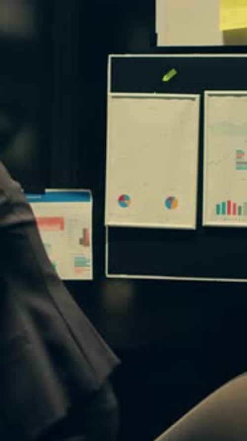 Businesswoman Working in an Office with Charts and Graphs